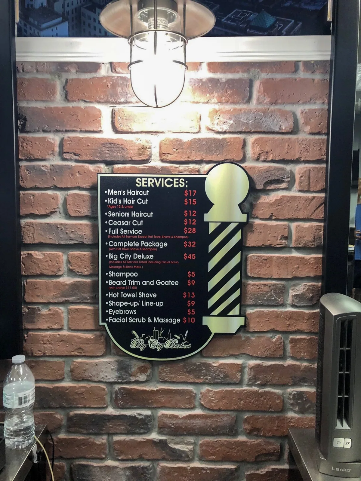 Big City Barbers — Services menu sign with barber pole graphic on a brick wall, Big City Barbers project