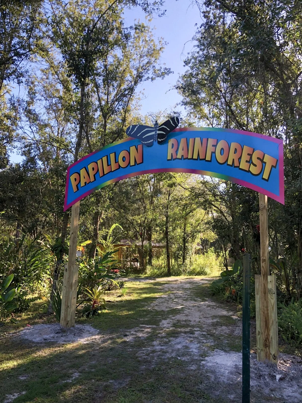 Butterfly Dans — Papillon Rainforest arch sign over a wooded trail, Butterfly Dan's project