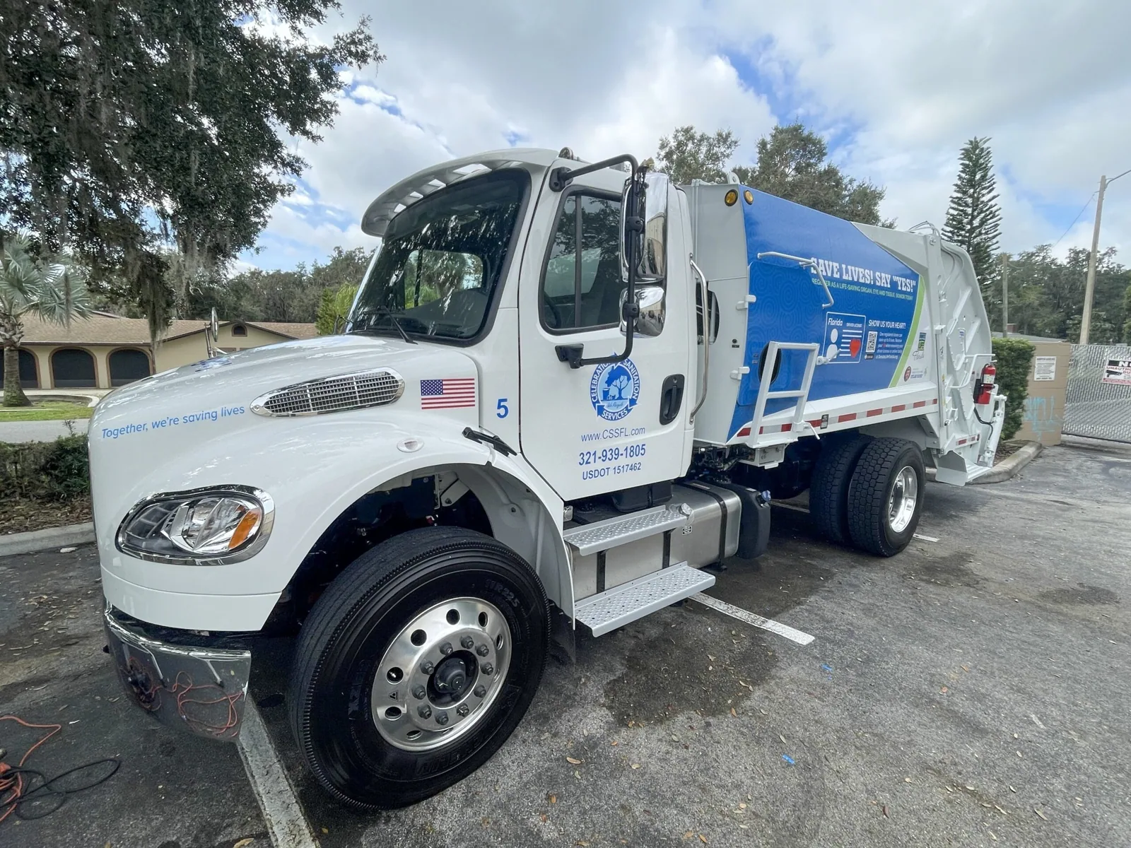 Celebration Sanitation — Front three-quarter view of the wrapped garbage truck in a parking lot, Celebration Sanitation project