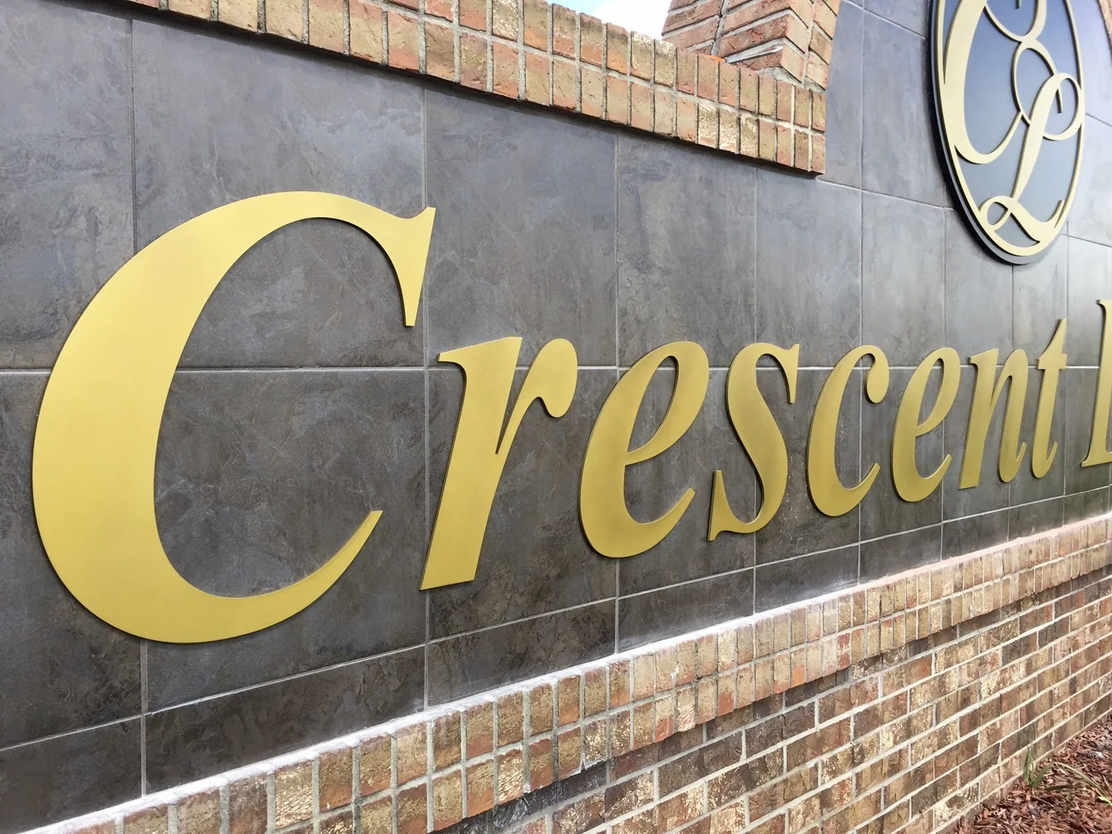 Crescent Lakes — Close-up of gold Crescent dimensional letters on a dark tile monument face, Crescent Lakes project