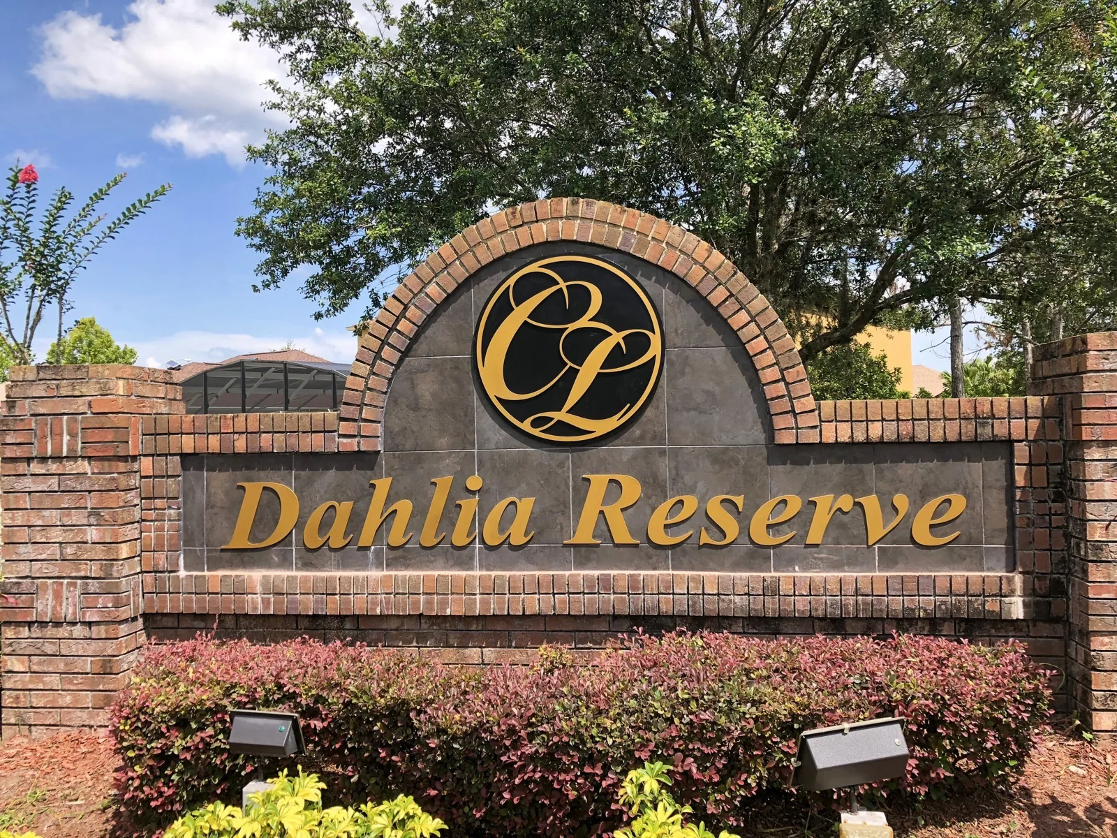 Crescent Lakes — Dahlia Reserve brick neighborhood monument sign with gold letters and CL logo, Crescent Lakes project