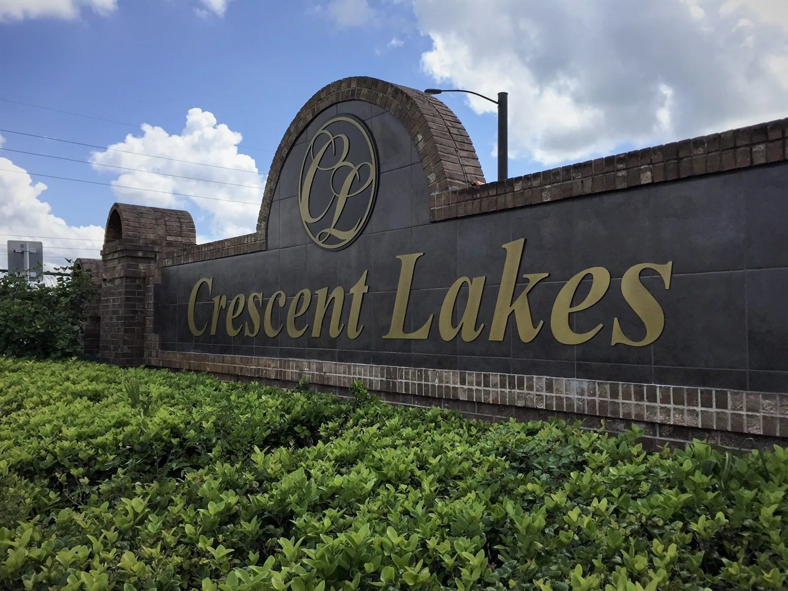 Crescent Lakes brick entrance monument with gold dimensional letters and CL logo, Crescent Lakes project