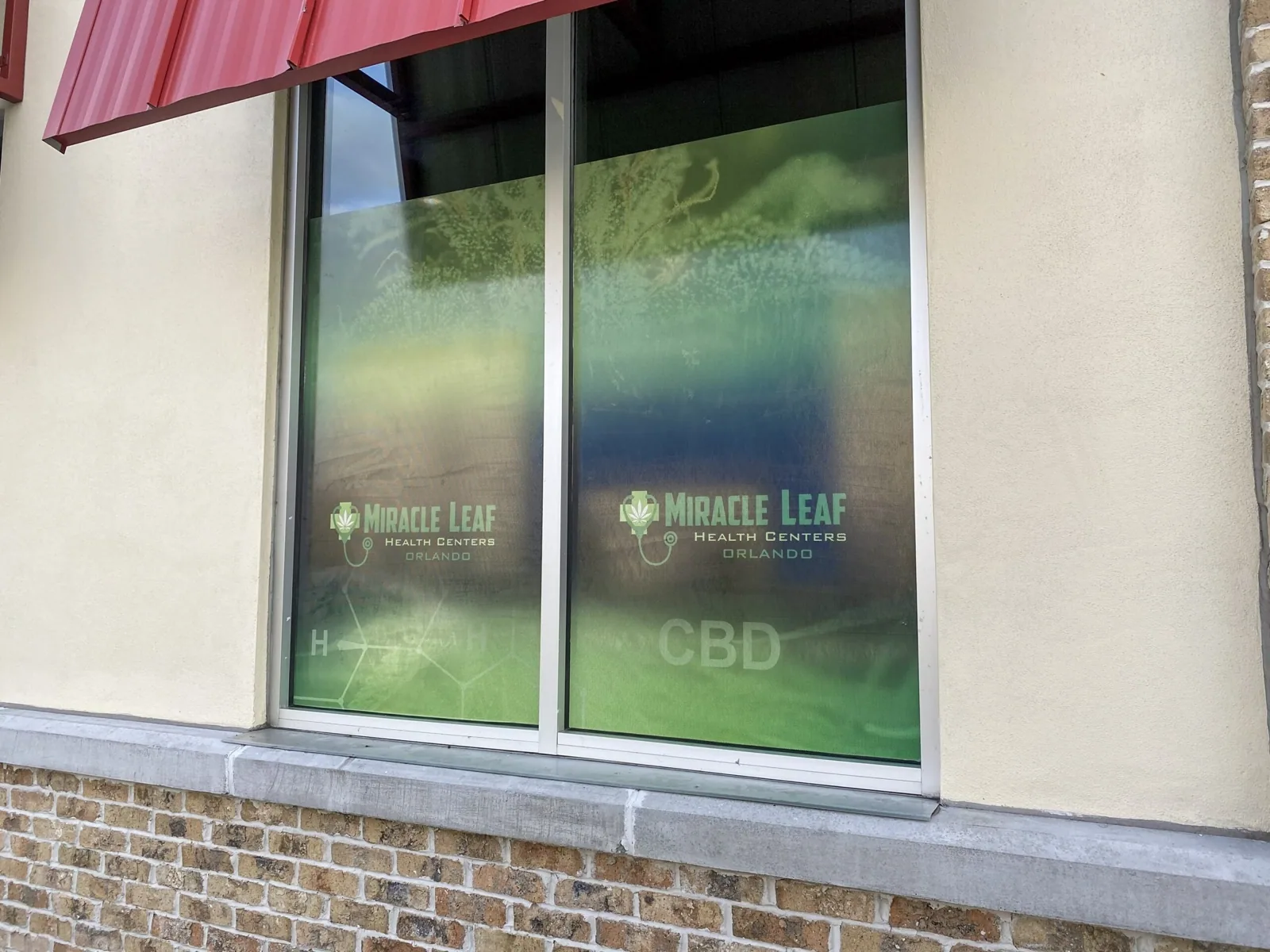 Miracle Leaf Orlando — Printed window graphics with Miracle Leaf logos on storefront windows, Miracle Leaf Orlando project