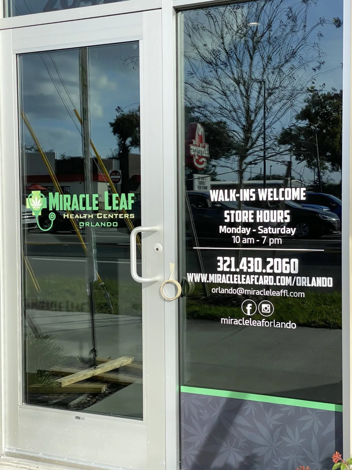 Miracle Leaf Orlando — Glass entry door with vinyl store hours, phone number and logo, Miracle Leaf Orlando project