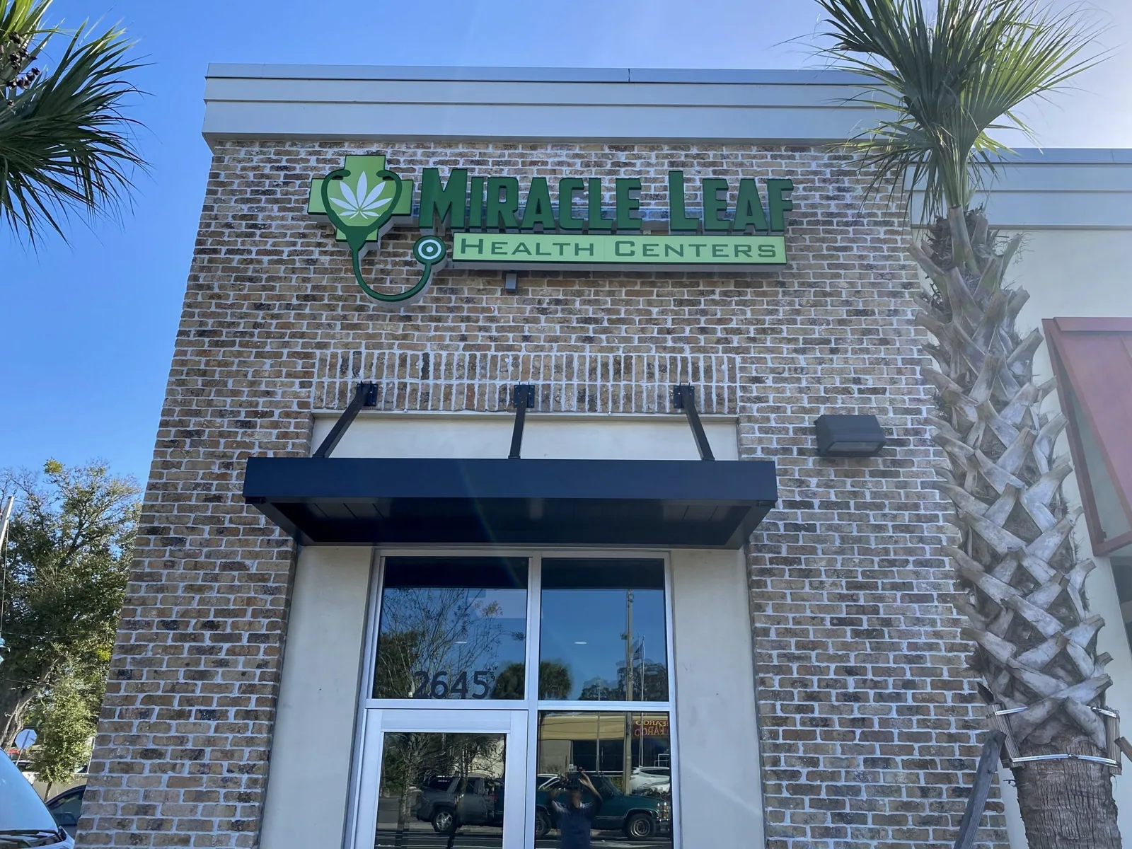 Miracle Leaf Health Centers sign with logo on a brick storefront above the entrance, Miracle Leaf Orlando project