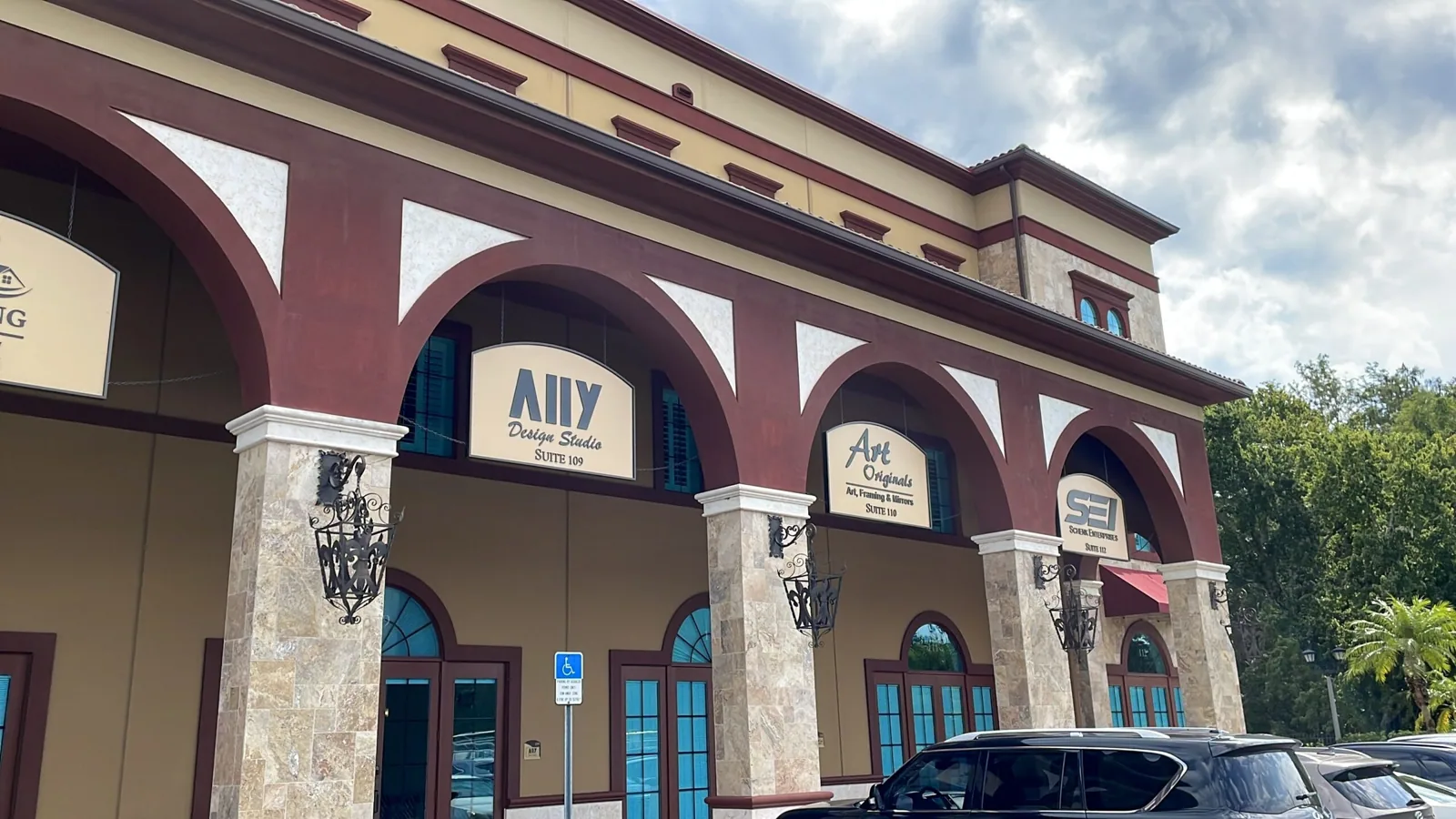 Schenk Enterprises — Wide view of the arched building with tenant hanging signs, Schenk Enterprises project