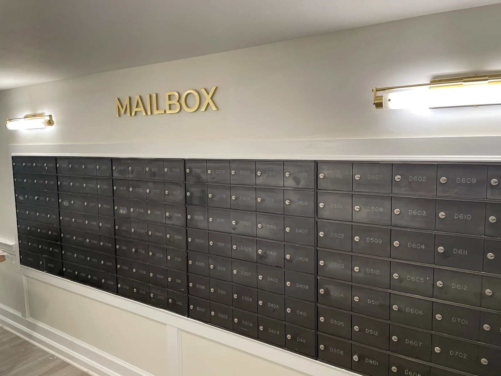 Unisen Senior Living — Gold MAILBOX dimensional letters above a wall of resident mailboxes, Unisen Senior Living project