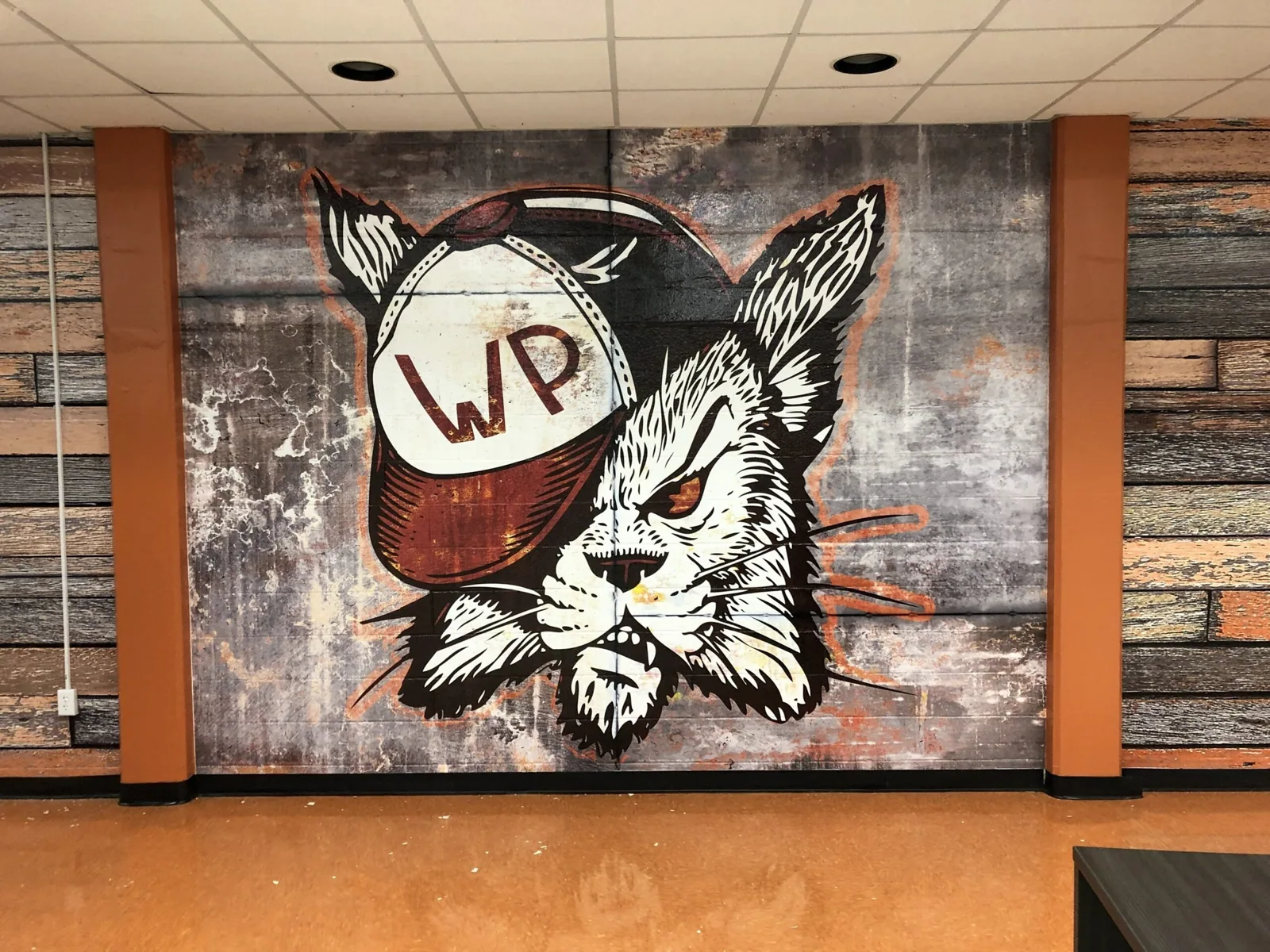 Winter Park High School — Wildcat mascot mural wall graphic with WP cap between wood-look wall panels, Winter Park High School project