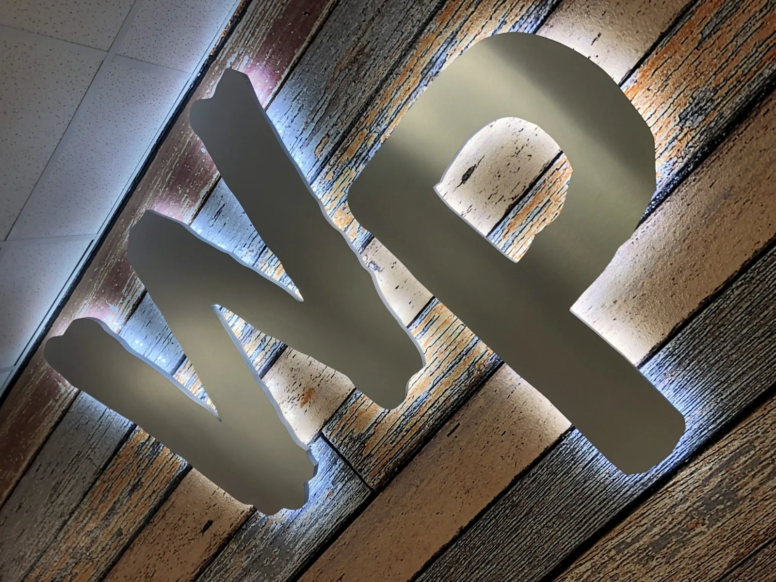 Winter Park High School — Backlit WP letters glowing against a wood-look wall graphic, Winter Park High School project