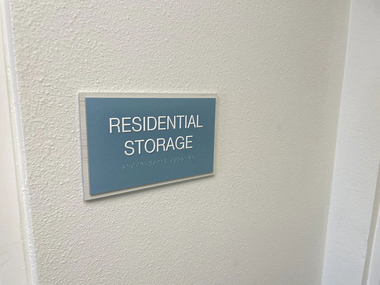 Residential Storage room sign with raised letters and Braille, Unisen Senior Living project