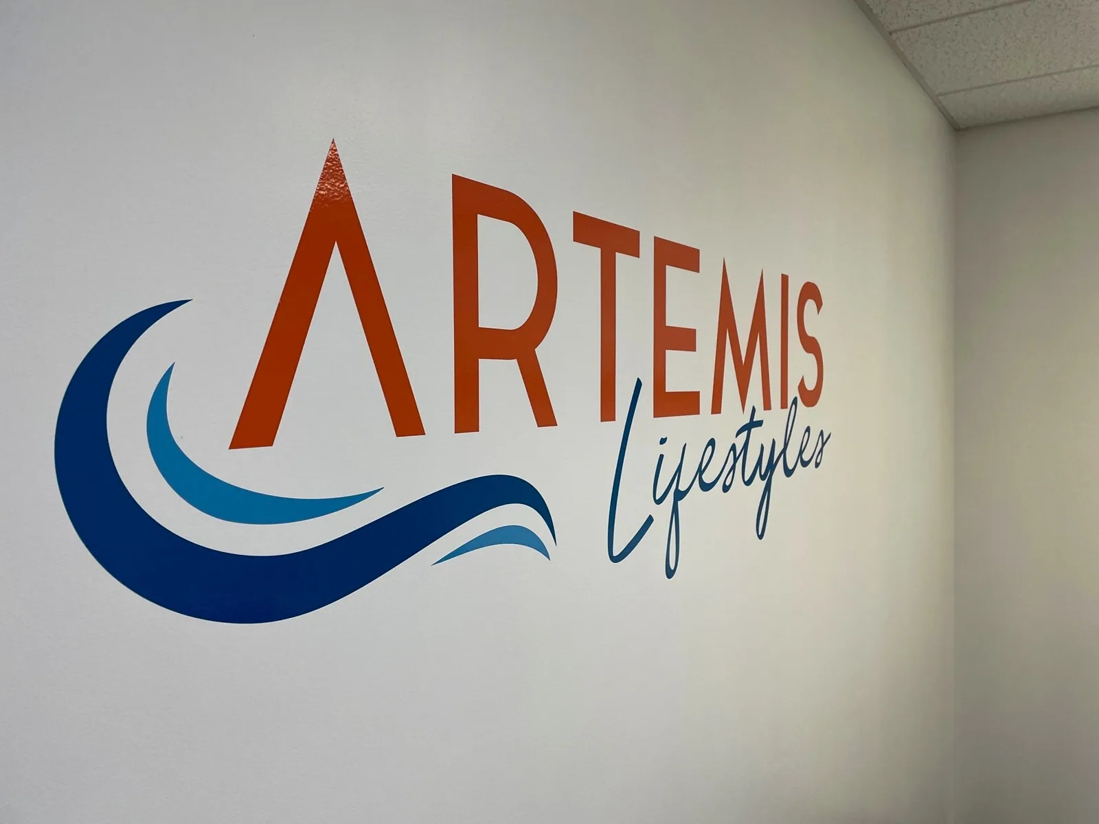 Artemis Lifestyles logo printed on a white interior wall