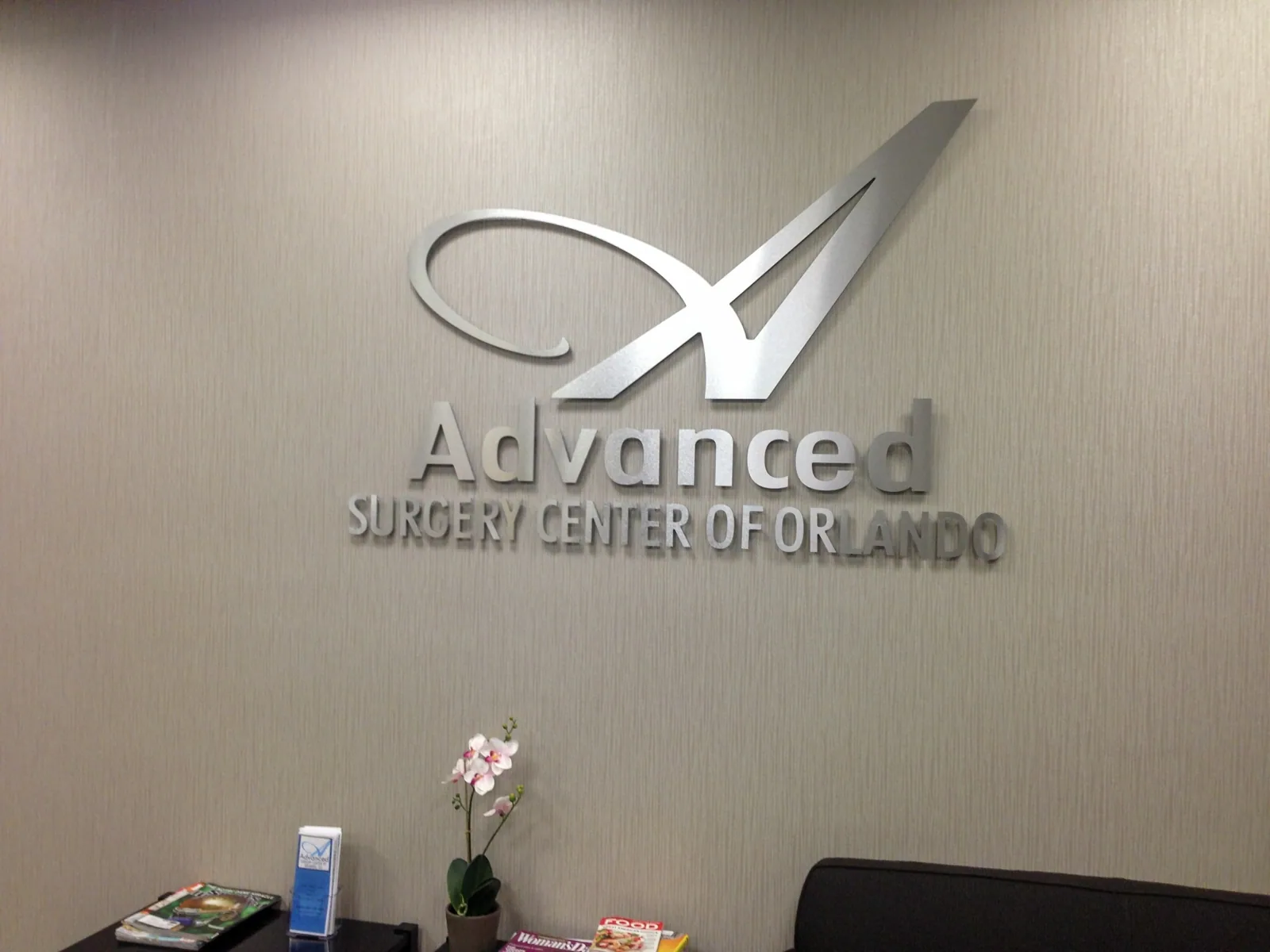 Advanced Surgery Center of Orlando silver dimensional logo on a lobby wall