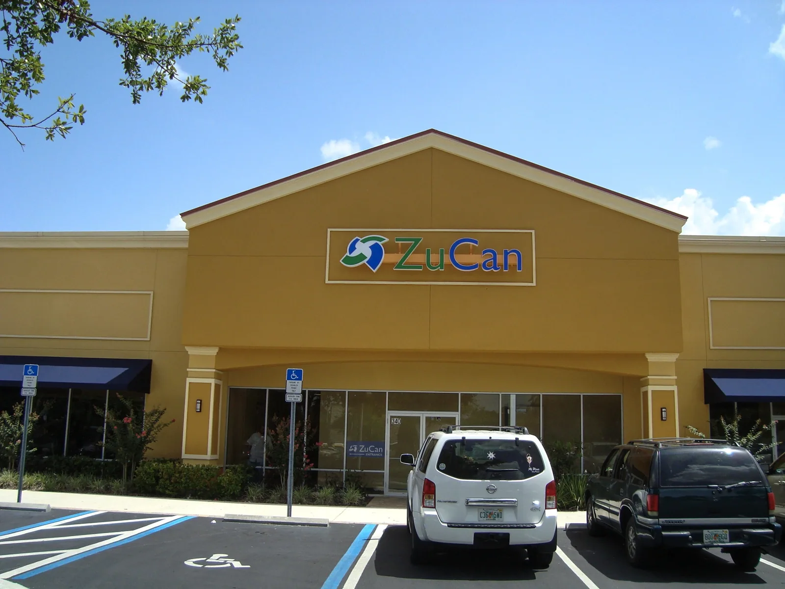 ZuCan sign on the gable of a yellow retail storefront