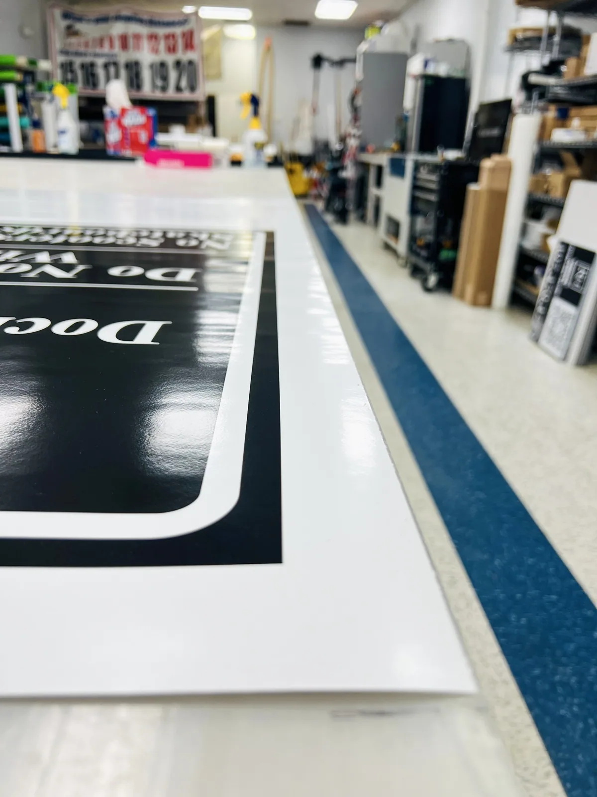 Printed sign panel lying on a shop worktable