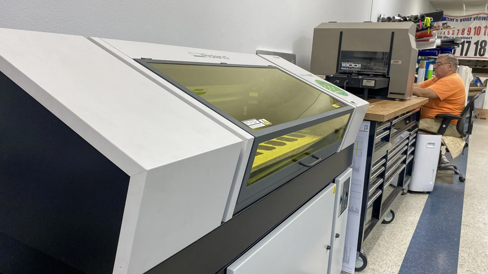 Flatbed UV printer with a tinted cover in a print shop